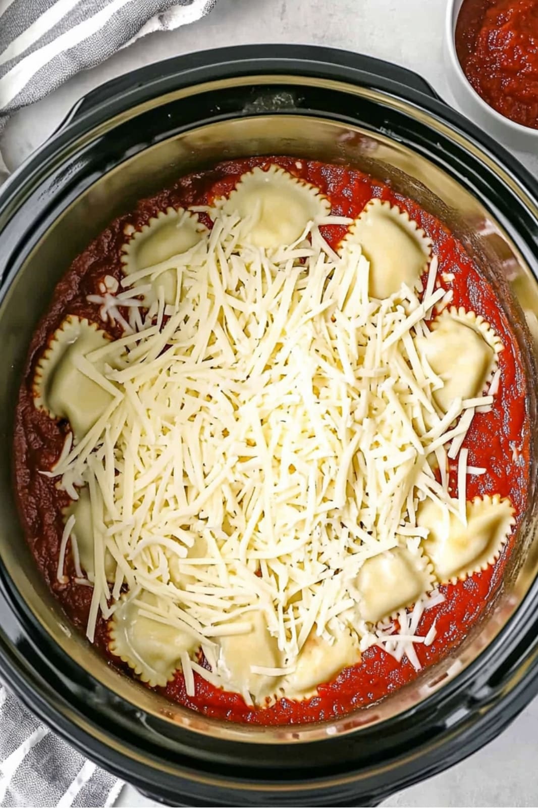 This crockpot ravioli lasagna recipe layers frozen ravioli, ground beef, spaghetti sauce, and mozzarella for a delicious, easy-to-make meal. Perfect for busy weeknights!