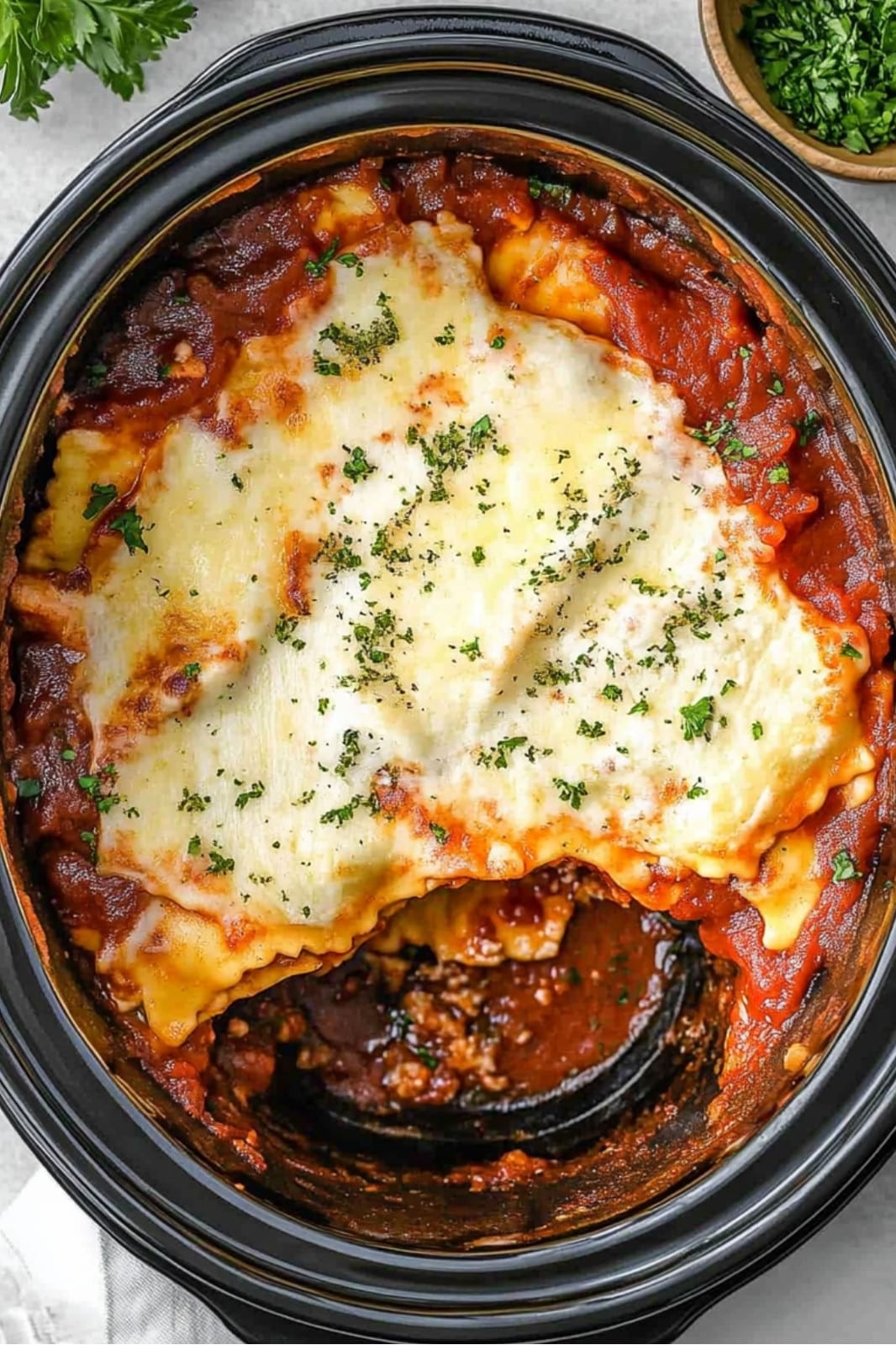 This crockpot ravioli lasagna recipe layers frozen ravioli, ground beef, spaghetti sauce, and mozzarella for a delicious, easy-to-make meal. Perfect for busy weeknights!