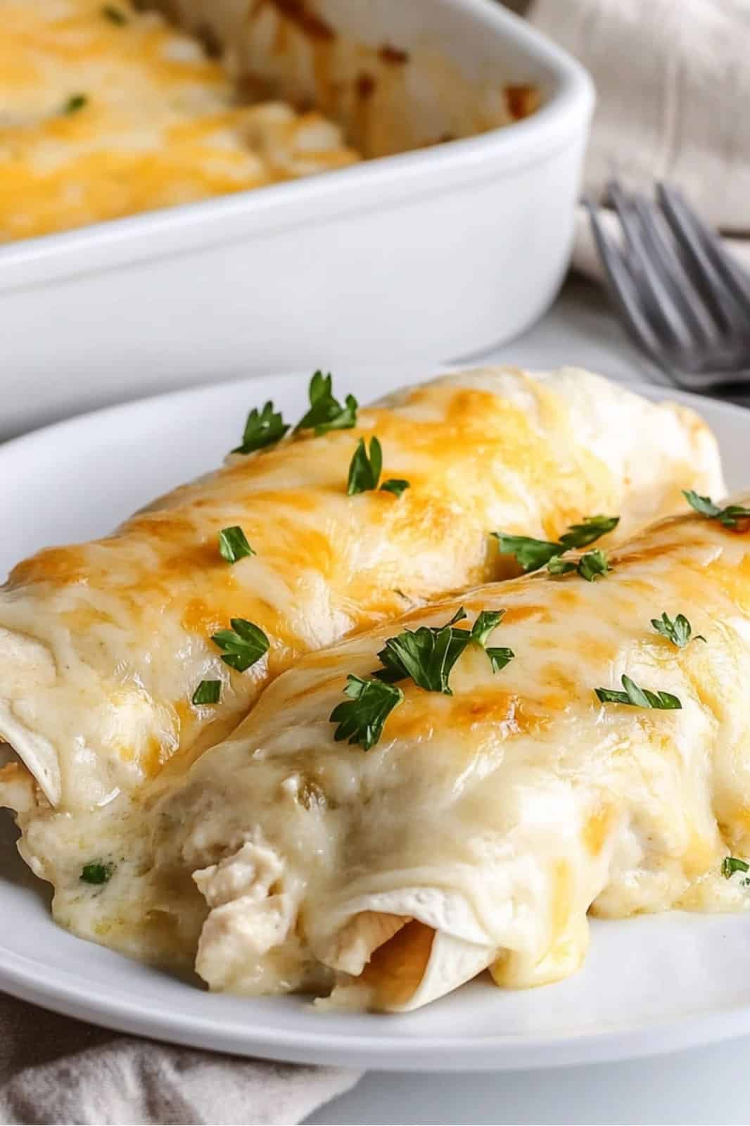 This White Chicken Enchiladas recipe is a creamy and delicious dish! Shredded chicken, cheese, and a rich sour cream sauce make these enchiladas the perfect weeknight meal, ready in 40 minutes.