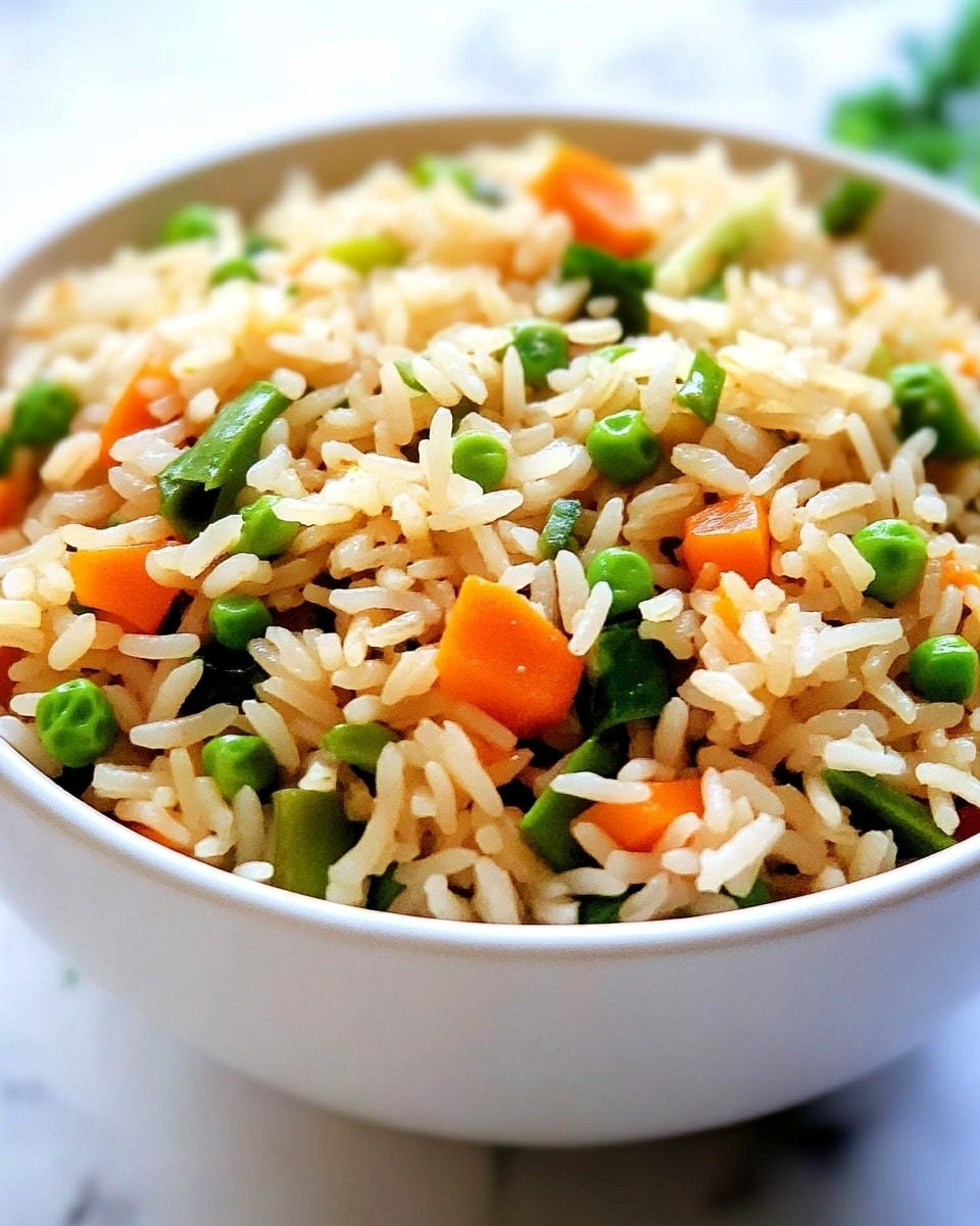 A close-up of a white fork holding a small bite of fried rice with visible layers of white and golden rice grains mixed with small pieces of orange carrot and green peas. The background is softly blurred but shows more fried rice in a dish with a dark rim. The overall look is warm and inviting with a focus on the texture of the rice and vegetables. photo taken with an iphone --ar 4:5 --v 6.1