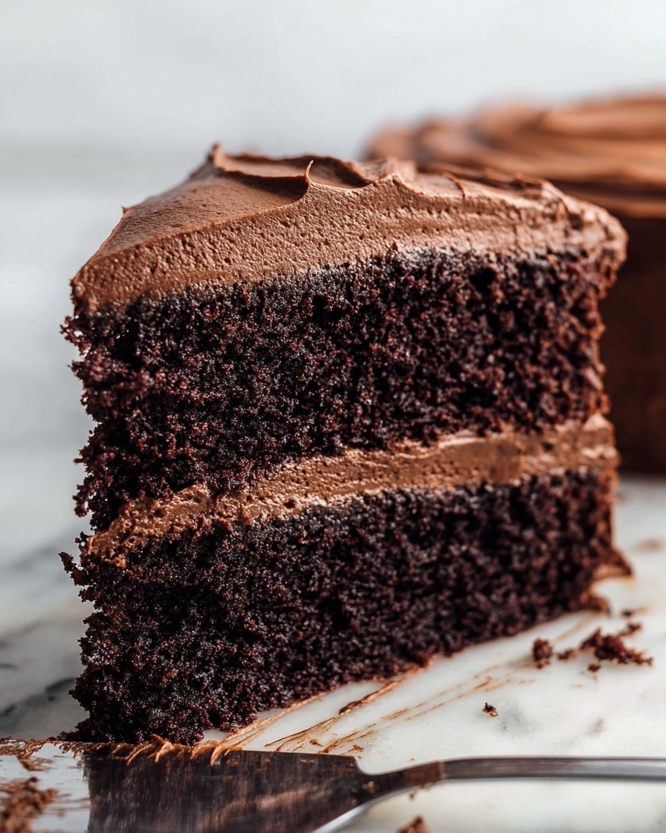 The image shows a round chocolate cake covered in rich, thick dark chocolate frosting that has been spread in smooth, swirling patterns on the top and sides. The cake appears to have two layers underneath the frosting, with a dense texture suggested by the frosting's firmness and thickness. The cake sits on a metal cooling rack over a white marbled surface, with no other decorations or colors present. The top frosting has a shiny and slightly textured look from the swirling strokes. photo taken with an iphone --ar 4:5 --v 7