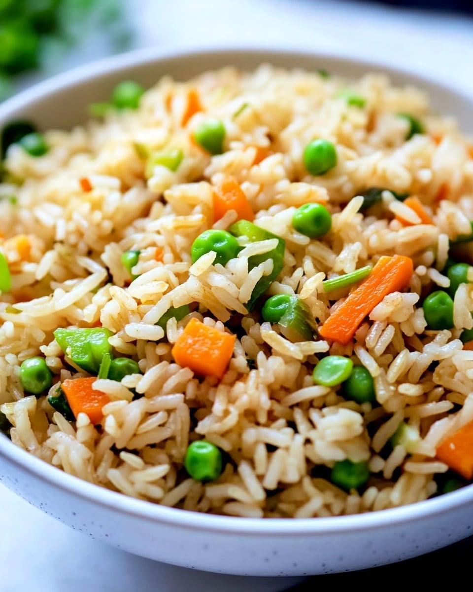 A close-up view of a bowl filled with cooked long-grain rice mixed with small chunks of green vegetables and orange carrot pieces, showing layers of fluffy grains interspersed with the colorful vegetable bits evenly spread throughout. The bowl is white, and the rice has a light brown tint with a slightly glossy texture, while the green vegetable pieces appear fresh and bright, sitting on a white marbled surface background. Photo taken with an iphone --ar 4:5 --v 6.1