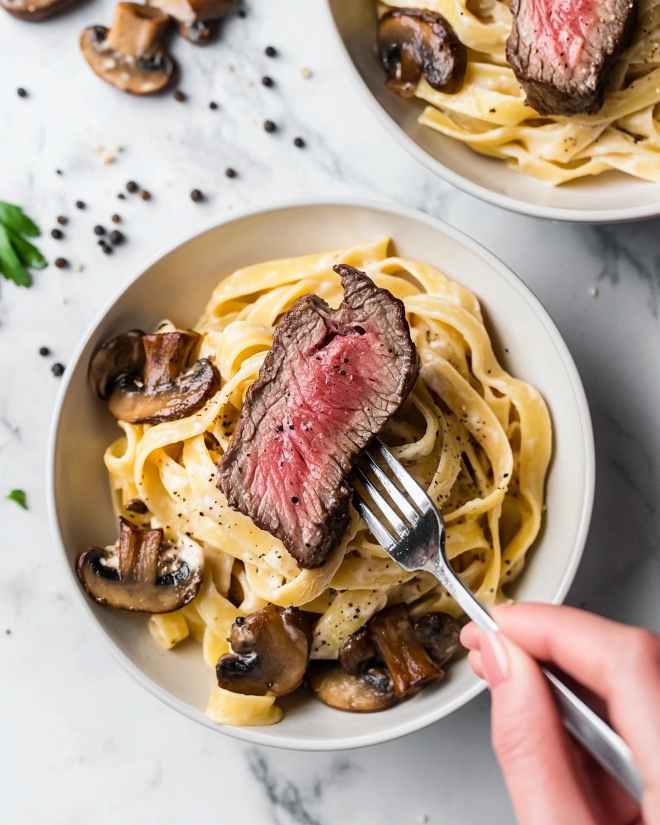 Two black bowls filled with a creamy mushroom pasta with wide, flat yellow noodles coated in sauce and dark sliced mushrooms mixed in as the bottom layer. On top of the pasta, there are five thick pieces of steak cooked medium, with a pink center and browned edges. In the foreground, sauce is being poured over the steak from a white jug held by a woman's hand, with scattered slices of fresh mushrooms and black peppercorns on the white marbled surface around the bowls. A silver fork rests on a brown napkin to the right of the nearest bowl. Photo taken with an iphone --ar 4:5 --v 6.1