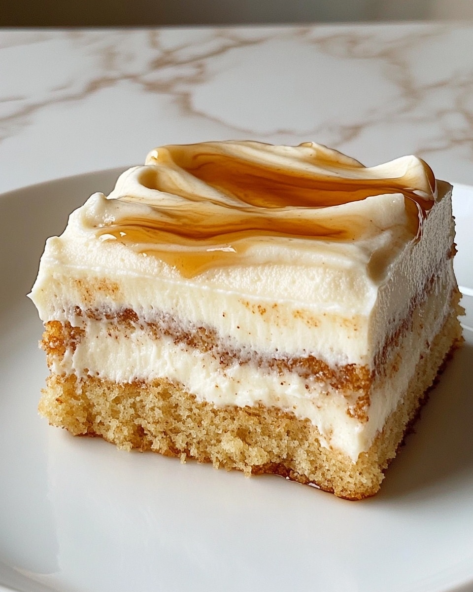 A close-up shot of a fork holding a piece of moist, brownish cake with small dark specks inside, showing a textured crumb layer. On top of the cake is a creamy, smooth layer of white frosting with a light brown drizzle adding a glossy finish. The fork rests on brown parchment paper placed on a white marbled surface. In the background, part of a larger cake with similar layers and frosting is slightly visible. photo taken with an iphone --ar 4:5 --v 6.1