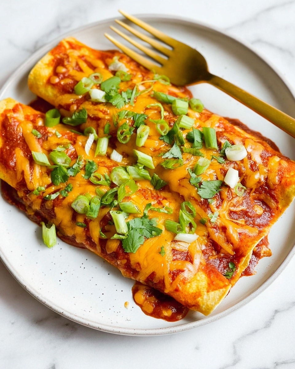 Two enchiladas are placed side by side on a white plate with a white marbled texture under it. Each enchilada has a soft, yellowish tortilla base, covered in a rich red sauce. On top of the sauce, melted orange-yellow cheese is spread unevenly, with small clumps and strands visible. Green sliced scallions and chopped cilantro leaves are scattered on the cheese, adding fresh green color spots. A gold fork rests on the right edge of the plate, shiny and sleek. The photo taken with an iphone --ar 4:5 --v 7