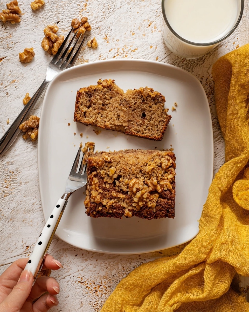 A white square plate sits on a white marbled textured surface, holding a thick slice of crumbly brown nut bread with a visible crunchy walnut topping. The bread shows a dense, moist texture with small nut pieces inside. On the plate beside the slice is a broken piece of the bread with a woman's hand holding a white fork with black dots stuck into the smaller piece. Another fork of the same design rests on the upper left corner of the plate. In the top right corner, there is a glass filled with white milk. A crumpled yellow cloth is positioned near the bottom right of the plate. Photo taken with an iphone --ar 4:5 --v 7