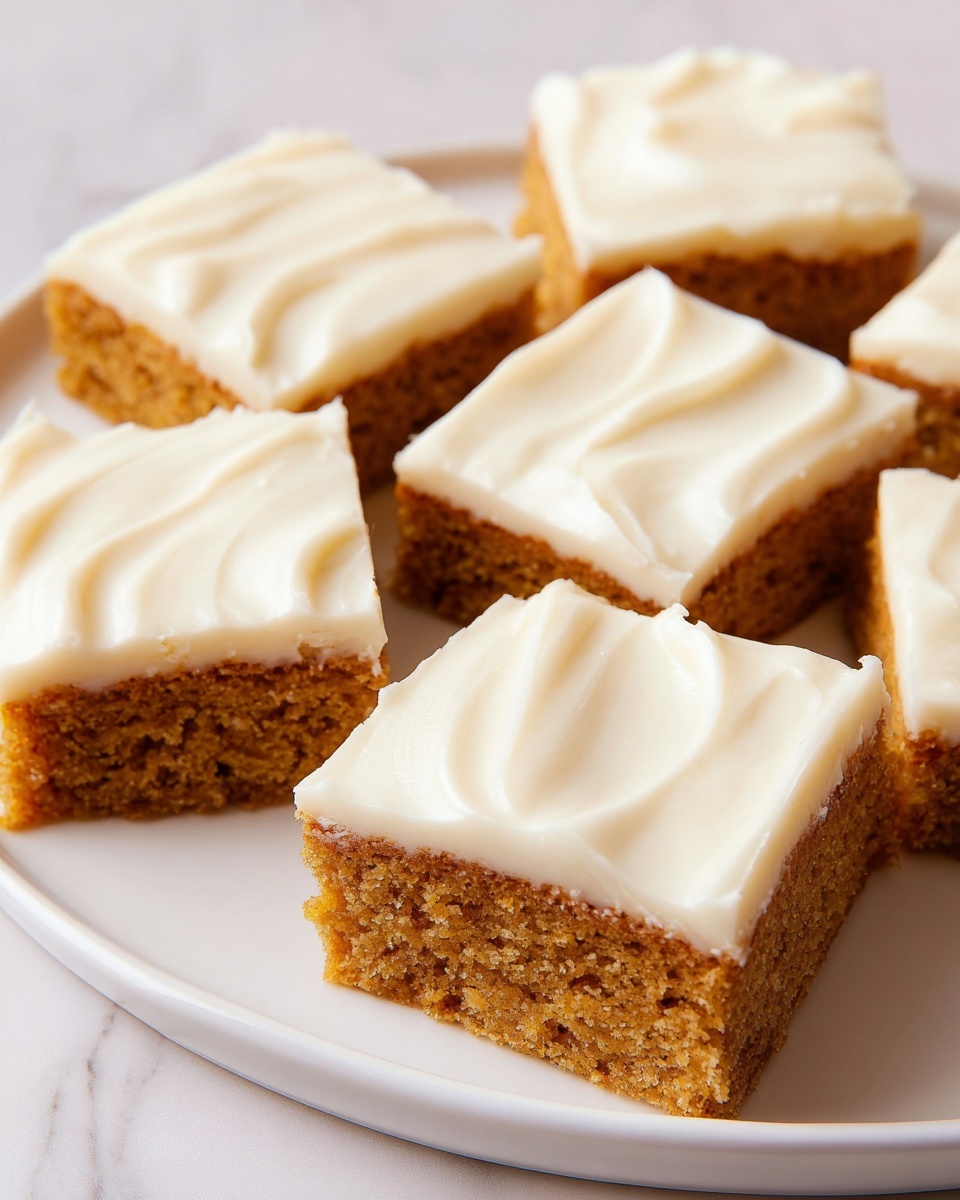 The image shows a square piece of orange-brown cake with a thick layer of smooth, white frosting on top, placed on a white plate. In front of the cake, a small piece is held by a silver fork resting on the plate. In the background, there is a white plate with several similar square cakes with the same white frosting. To the right, there is a brown cup, likely with a hot drink. The whole setting is on a white marbled surface. photo taken with an iphone --ar 4:5 --v 7