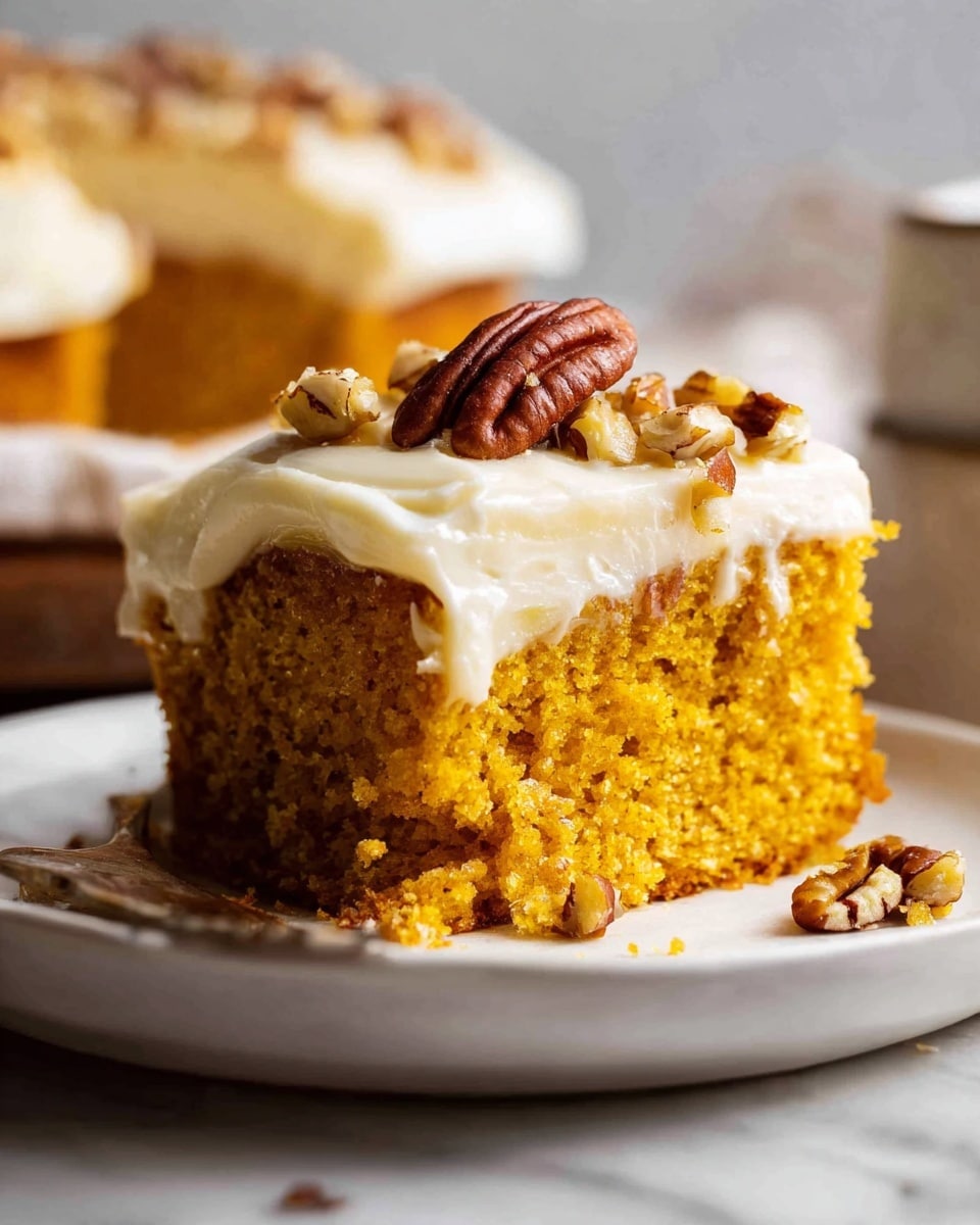 The image shows a creamy layer of light beige frosting spread smoothly in a roughly square shape on a white marbled surface. Swirls of dark caramel sauce are added on top in uneven pools, blending into the frosting in some places. Scattered over the frosting and caramel are small, chopped pieces of pecans, adding a mix of brown tones and rough textures. Dried leaves with shades of yellow, orange, and red rest gently on the edge of the frosting, adding a natural touch. Photo taken with an iphone --ar 4:5 --v 7