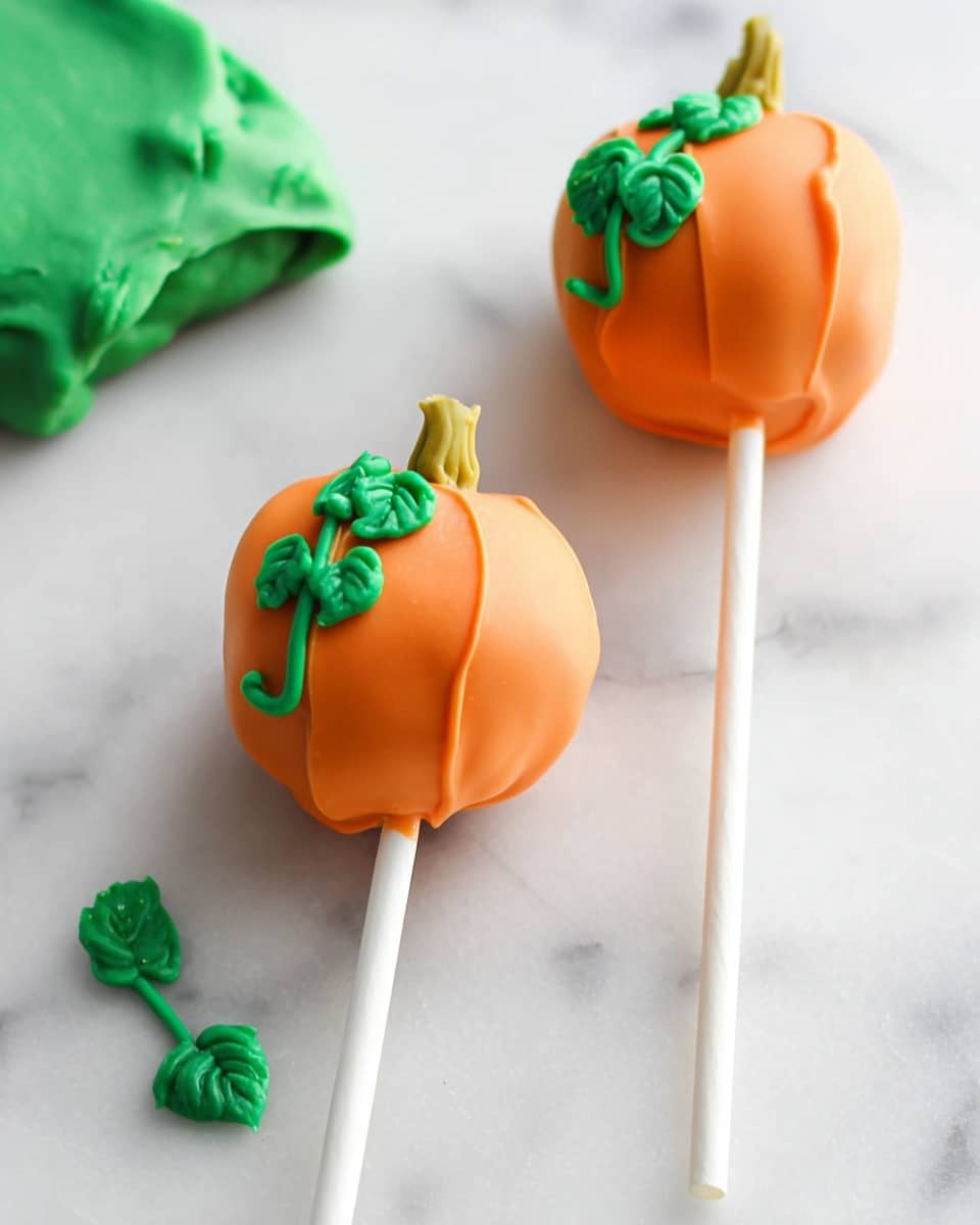 The image shows four round cake pops that look like small pumpkins. Each cake pop has three layers: the inside is a light brown with small dark bits, the outside is coated with smooth orange icing, and a small green icing stem with a little leaf sits on top. The cake pops are on white sticks standing upright on white paper over a white marbled surface. Three cake pops are blurred in the background on a white plate, while one cake pop in the foreground has a bite taken out, showing the inside. A blurred large pumpkin is seen in the far background. The lighting is bright and soft. photo taken with an iphone --ar 4:5 --v 7
