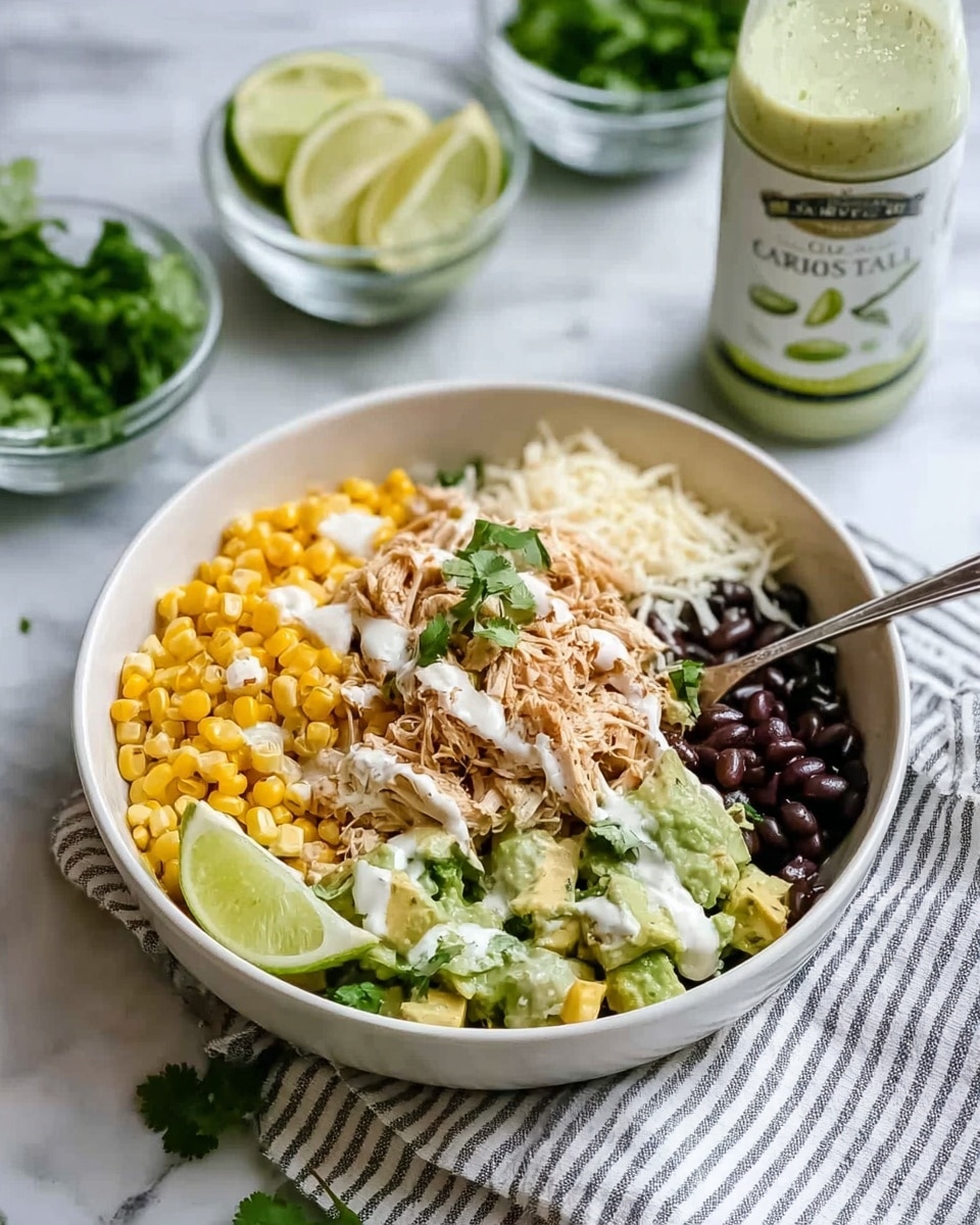 A white bowl with four main layers arranged side by side: bright yellow corn kernels on the left front, tender shredded light brown chicken with some green cilantro leaves and white sauce drizzled over it in the middle left, creamy light green avocado chunks on the right front, and small shiny black beans in the back. There is a light wedge of lime placed on the left side of the bowl next to the corn. White shredded cheese and a few sprigs of cilantro sit between the shredded chicken and avocado layers. A silver fork rests in the bowl, near the avocado on the right side. The bowl is placed on a white marbled surface with a striped cloth underneath, and in the background are small clear bowls with more avocado, lime, corn, and a bottle of green sauce. photo taken with an iphone --ar 4:5 --v 7