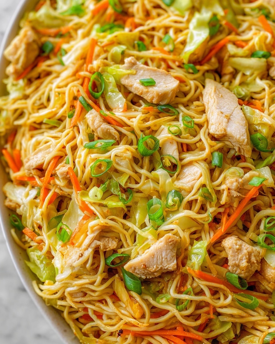 A close-up view of a noodle dish with thin yellow noodles forming the base layer, mixed with thin orange carrot strips and light green cabbage pieces scattered evenly throughout. Pale tan pieces of cooked chicken are spread on top, along with small slices of bright green onion scattered as the final layer, giving a fresh look. The textures show soft noodles, tender chicken, and crisp vegetables mixed together. The scene is set on a white marbled surface. photo taken with an iphone --ar 4:5 --v 7