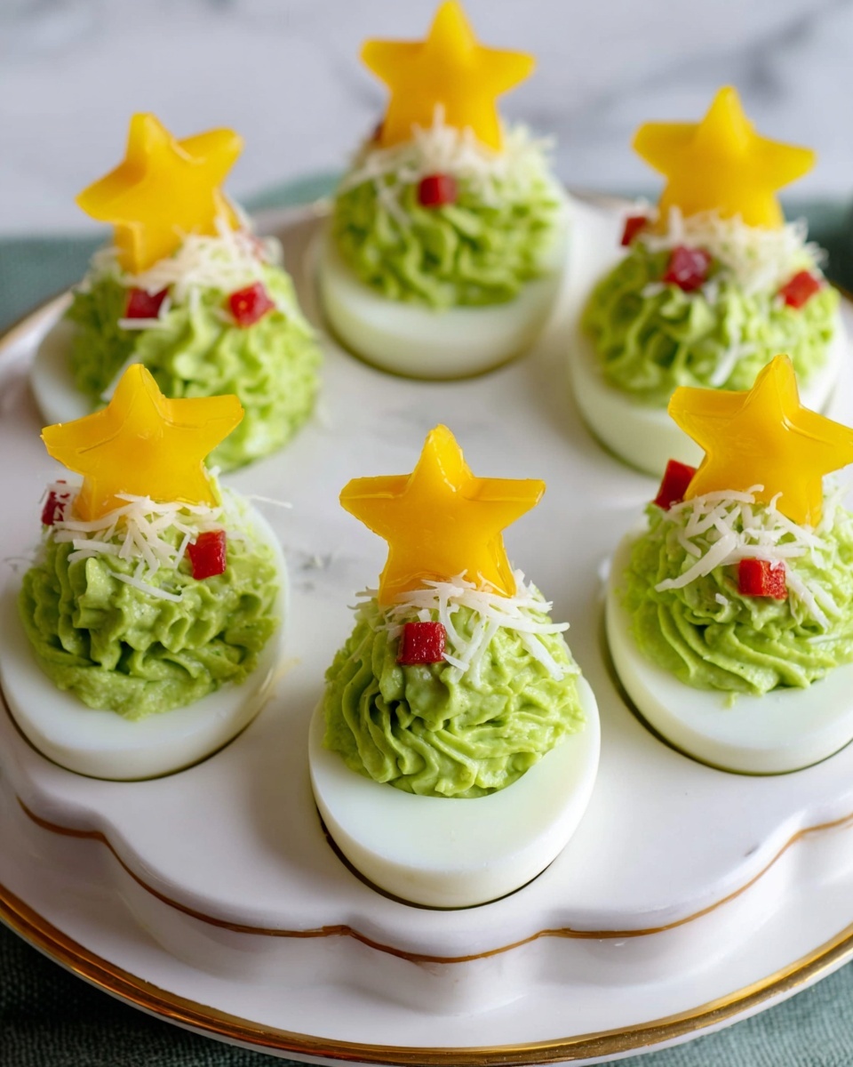 Christmas Tree Deviled Eggs with Avocado Recipe 6 The image shows six deviled eggs arranged in a white egg holder with a gold rim, sitting on a white marbled surface. Each egg has a smooth white base with a vibrant green creamy filling piped in a swirl that looks like a small tree with texture. Tiny red diced pieces are scattered on the green filling as decoration. On top of each green swirl, there is a yellow star-shaped piece that looks like cheese or bell pepper, acting as a tree topper. Light bits of shredded white garnish are sprinkled over the green filling. The setup is neat and festive, designed to look like small Christmas trees. photo taken with an iphone --ar 4:5 --v 7