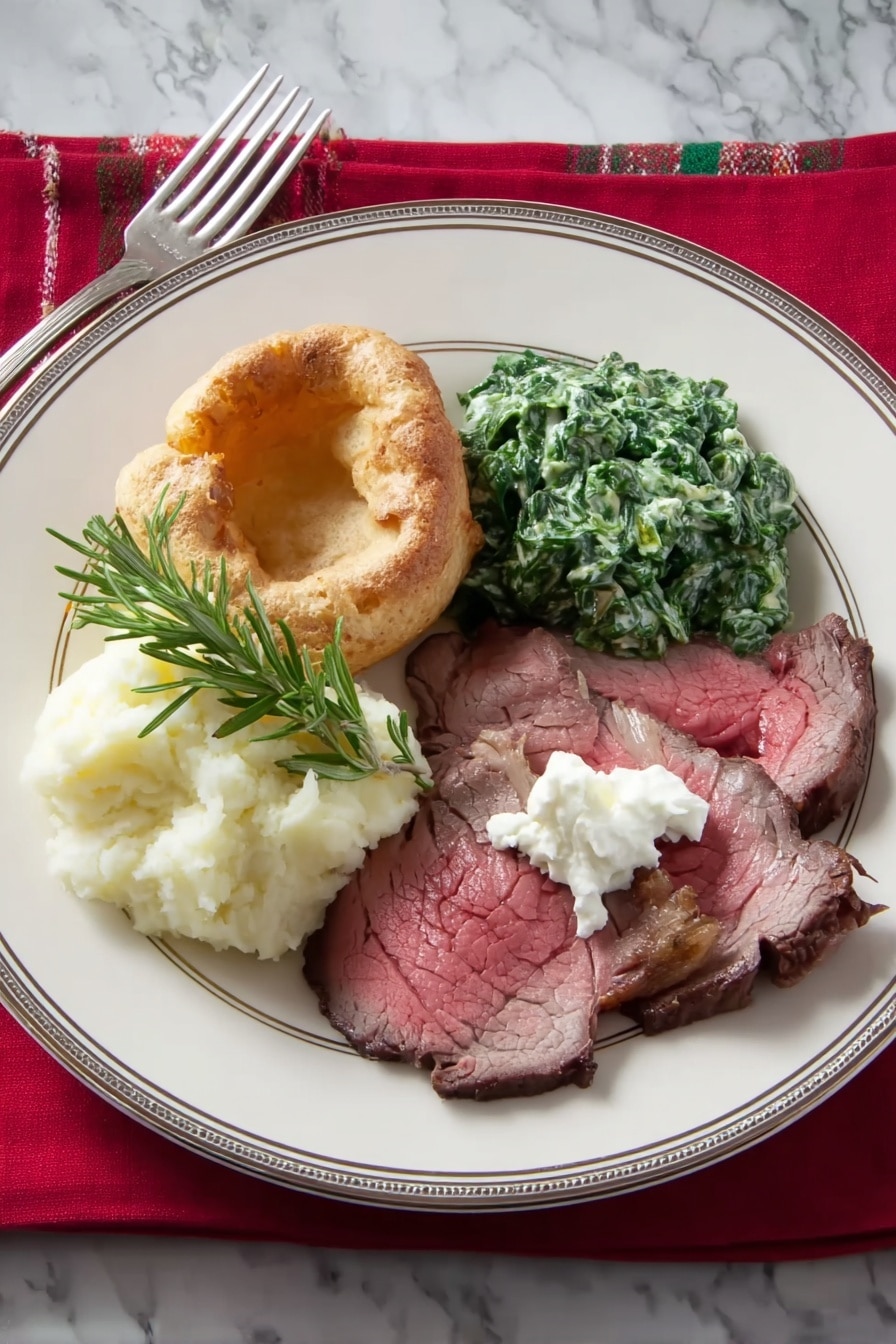 On a white plate with a thin silver rim, there are four main items arranged in a circular pattern. At the bottom right are thin slices of roasted beef, pinkish-red in the middle and browned on the edges, topped with a dollop of white creamy horseradish. To the right center, there is a mound of green creamed spinach, thick and textured. At the top left, there is a small portion of fluffy white mashed potatoes. Overlapping the mashed potatoes on the left side of the plate is a light golden Yorkshire pudding with a slightly crispy surface. A sprig of green rosemary lies on top of the beef slices. The plate is on a white marbled surface, with a red cloth napkin and a silver fork to the left side. Photo taken with an iphone --ar 2:3 --v 7 - Perfect Prime Rib Roast, prime rib roast, juicy prime rib, tender prime rib, holiday roast