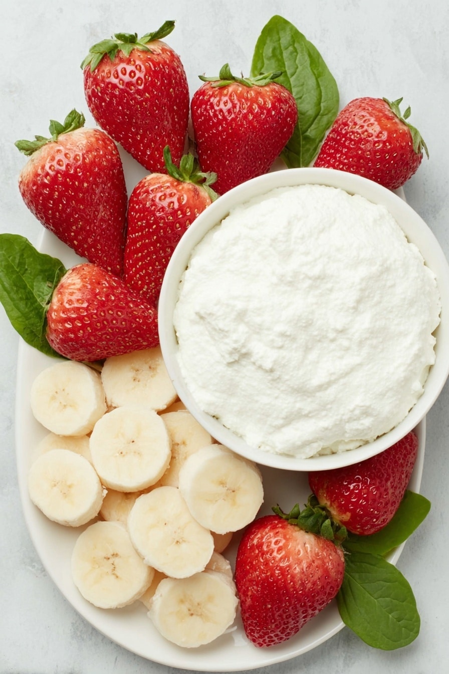 Flat lay of a dozen bright red strawberries with fresh green leaves, a ripe yellow banana sliced into round discs, a small white ceramic bowl filled with creamy white ricotta cheese, all arranged symmetrically on a clean white ceramic plate, placed on a clean white marble surface, soft natural light, photo taken with an iPhone, professional food photography style, fresh ingredients, white ceramic bowls, no bottles, no duplicates, no utensils, no packaging --ar 2:3 --v 7 --p m7354615311229779997 - Healthy Strawberry Santas, healthy holiday snacks, festive fruit treats, quick healthy snacks, adorable fruit appetizers