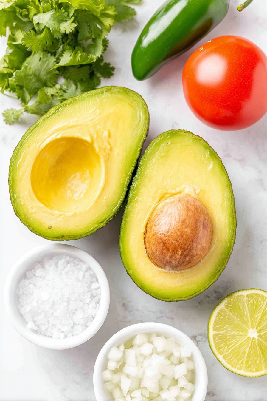 Easy Ripe Avocado Guacamole Recipe 7 Flat lay of two large ripe avocados halved showing bright green flesh and brown pits, one whole Roma tomato with smooth red skin, one fresh green jalapeño pepper, a small bunch of bright green cilantro sprigs, a quarter of a small white onion finely diced in a simple white ceramic bowl, fresh lime cut in half with one half juiced and a small white bowl containing lime juice, and a small white bowl filled with coarse kosher salt, all arranged with perfect symmetry, placed on a clean white marble surface, soft natural light, photo taken with an iPhone, professional food photography style, fresh ingredients, white ceramic bowls, no bottles, no duplicates, no utensils, no packaging --ar 2:3 --v 7 --p m7354615311229779997 - Easy Ripe Avocado Guacamole, avocado guacamole recipe, quick guacamole, healthy avocado dip, best homemade guacamole