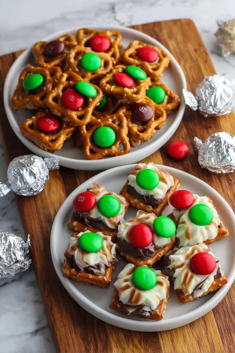 The image shows a close-up view of many small square pretzels laid out neatly on a white marbled surface. Each pretzel has two layers: the base pretzel square is golden brown with a slightly rough texture. On top of each pretzel is either a smooth white and brown striped candy or a round milk chocolate piece. Each candy or chocolate has a small bright red or green candy M in the center, adding a pop of color. The layers are evenly spaced, creating a tidy and colorful pattern. Photo taken with an iphone --ar 2:3 --v 7 - Hershey's Kiss Pretzel Bites, salty and sweet snack, quick party treats, easy holiday snack, chocolate and pretzel combo