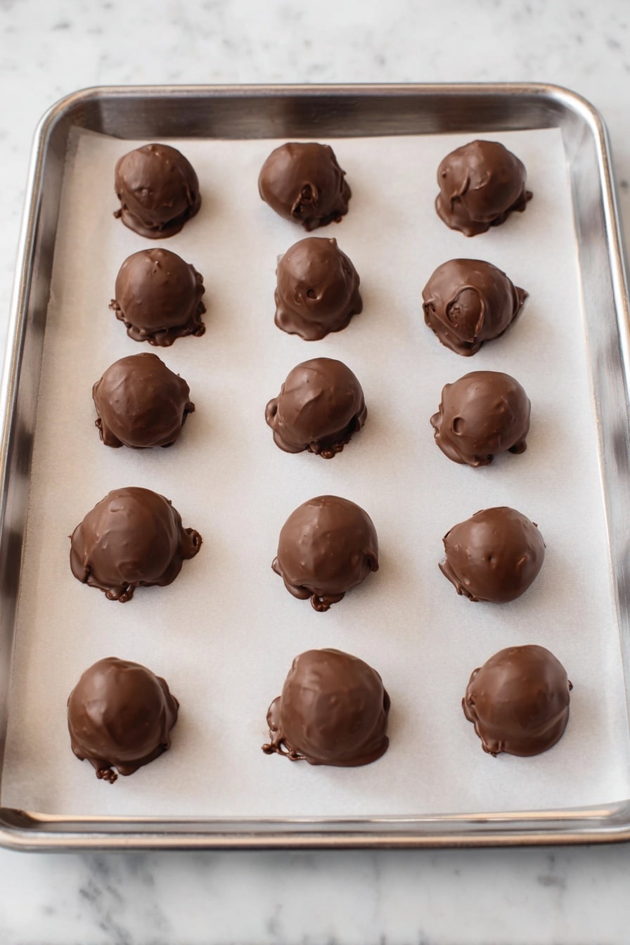 There are several round chocolate balls with a smooth brown outer layer stacked on a wooden board. Each ball is decorated with thin white stripes running down the top and colorful small candy pieces scattered on them and around the board. The top chocolate ball has a bite taken out, revealing a creamy white inside layer. In the background, to the left, there is a clear glass bowl filled with the same colorful candies, and to the right, there is a white plate holding more chocolate balls. The surface under everything is a white marbled texture. photo taken with an iphone --ar 2:3 --v 7 - No-Bake Cheesecake Bites with Chocolate, easy cheesecake bites, no-bake dessert recipes, chocolate cheesecake treats, simple dessert ideas
