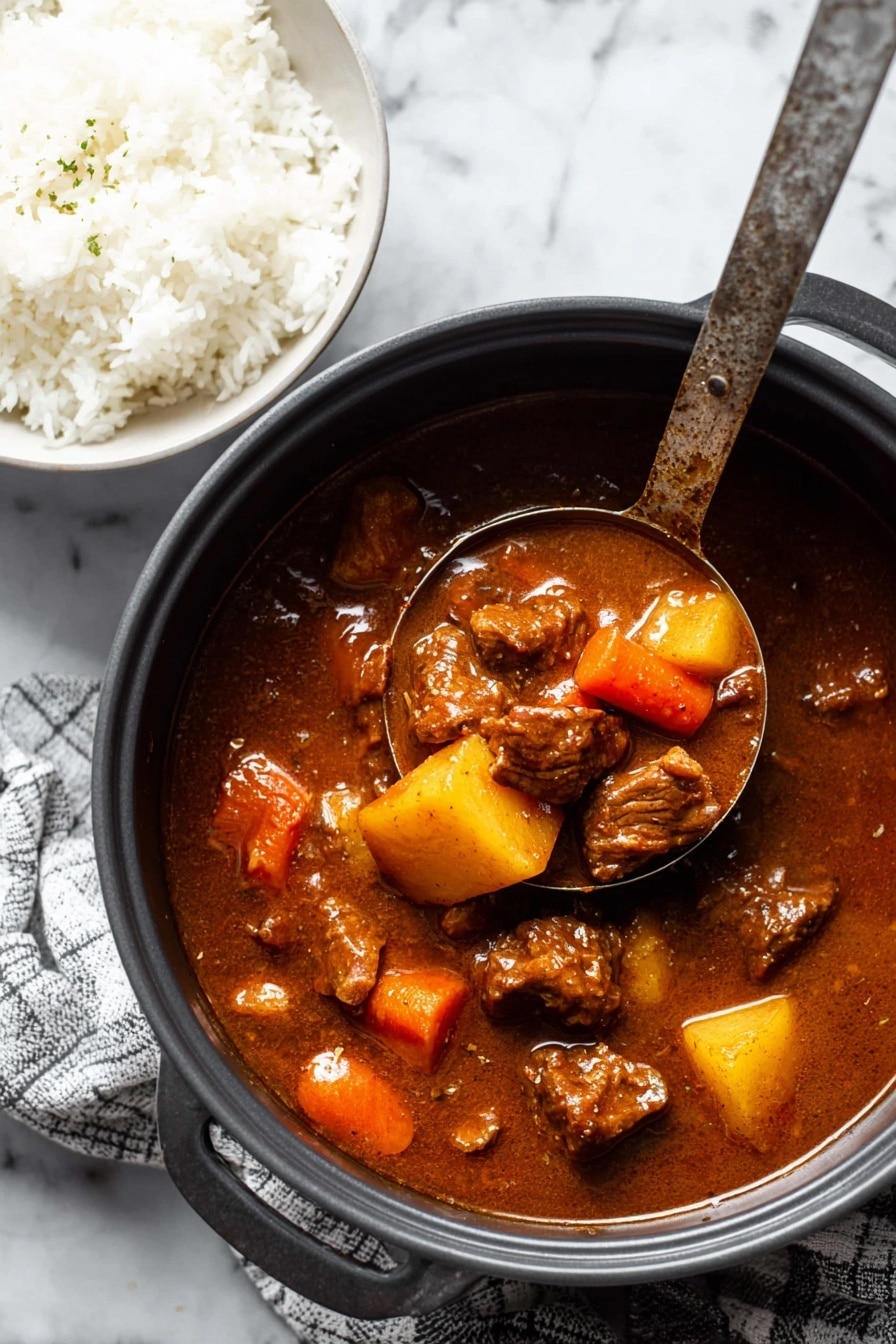 A white bowl holds a dish with two distinct layers: on one side, there is fluffy white rice with rounded grains, and on the other side, a rich brown stew with large chunks of meat and soft, thick pieces of orange carrots and yellow potatoes. The stew looks thick and glossy, covered in a reddish-brown sauce that lightly coats the ingredients. There are specks of black pepper sprinkled over the stew, adding texture and contrast. A silver spoon rests on the side of the bowl, partially immersed in the stew. All this is set on a white marbled surface. photo taken with an iphone --ar 2:3 --v 7 - Hawaiian Beef Stew, Hawaiian Beef Stew Recipe, Hawaiian Beef Stew preparation, Hawaiian Beef Stew ingredients, Hawaiian Beef Stew dinner ideas