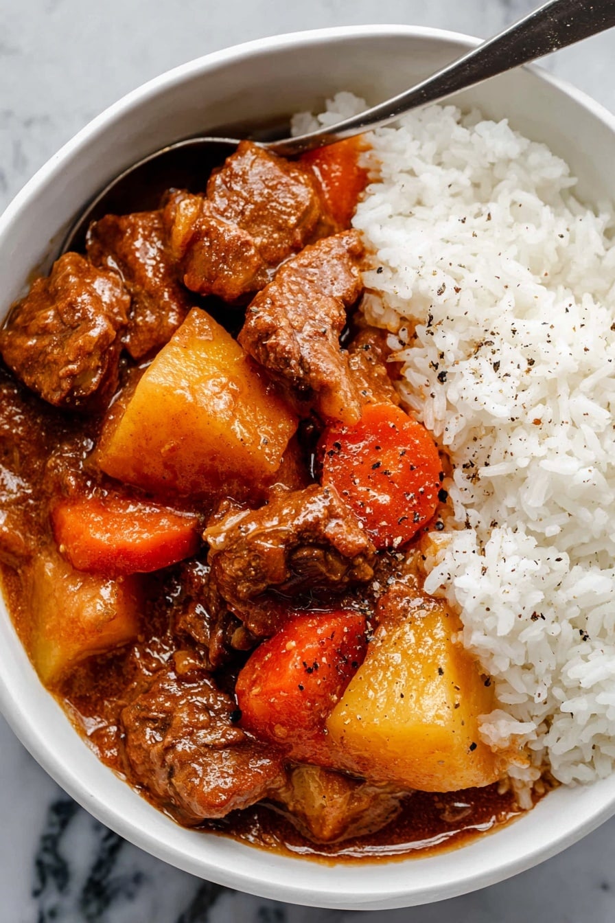 Hawaiian Beef Stew Recipe 8 The image shows a close-up of a dark gray pot filled with thick brown stew. Inside the stew, there are chunks of brown meat, bright orange carrot pieces, and large yellow potato cubes scattered evenly throughout. A metal ladle with a rough handle is lifting some of the stew, showing a mix of meat, potato, and carrots with a smooth brown sauce coating everything. Next to the pot, there is a white bowl filled with fluffy white rice, which is placed on a white marbled surface. A gray and white checkered cloth is also visible under the pot. photo taken with an iphone --ar 2:3 --v 7 - Hawaiian Beef Stew, Hawaiian Beef Stew Recipe, Hawaiian Beef Stew preparation, Hawaiian Beef Stew ingredients, Hawaiian Beef Stew dinner ideas