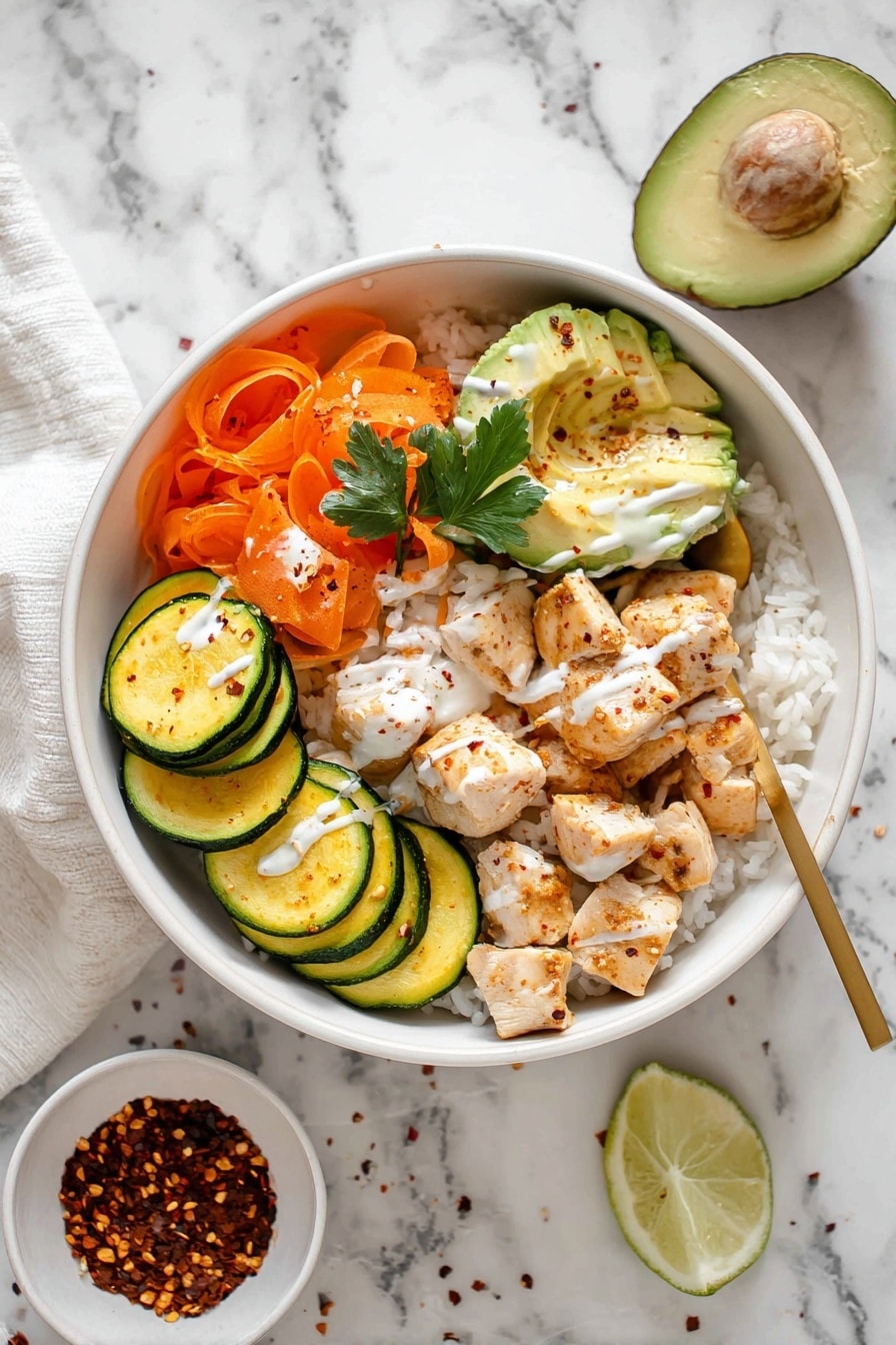 Hot Honey Chicken Rice Bowls Recipe 8 The dish is served in a white bowl filled with a base layer of white rice, topped with several sections: cooked round slices of green and yellow zucchini arranged along one side, shredded orange carrots with a parsley leaf on top, several pieces of cooked cubed chicken covered lightly with a white sauce and chili flakes, and three slices of fresh light green avocado. A wedge of lime lies on the rice next to the avocado. The bowl is placed on a white marbled surface with a small white bowl of chili flakes nearby. A gold spoon rests inside the bowl by the carrots and chicken, and a drizzle of white sauce is seen over the chicken and zucchini. Photo taken with an iphone --ar 2:3 --v 7 - Hot Honey Chicken Bowls, spicy sweet chicken rice bowls, easy chicken bowl recipes, weeknight dinner ideas, flavorful chicken rice dish