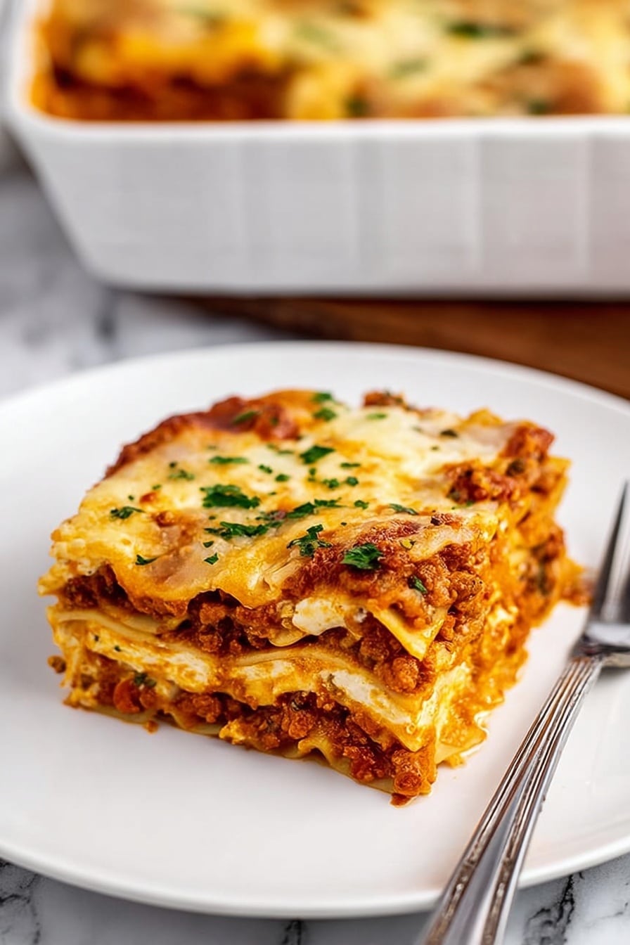 A square piece of lasagna sits on a white plate with a silver fork beside it. The lasagna shows several layers: a bottom layer of pasta sheets topped with a thick, reddish-brown meat sauce mixed with small bits of vegetables, followed by a creamy, pale yellow cheese layer, then another layer of pasta, sauce, and cheese. The top layer is melted golden cheese, with a few green parsley sprinkles. The background is a white marbled surface with a white baking dish filled with more lasagna blurred in the back. The photo taken with an iphone --ar 2:3 --v 7 - Homemade Italian Sausage Lasagna, Italian sausage lasagna, hearty lasagna recipe, cheesy lasagna with sausage, easy Italian dinner