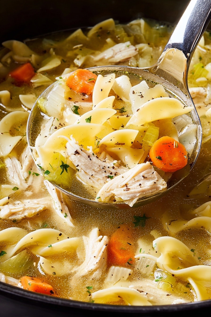 A close-up scene of a ladle scooping chicken noodle soup from a pot. The soup has three main layers: chunky white onion and celery pieces with bright orange carrot slices, tender white shredded chicken pieces, and wide, flat yellow egg noodles with a soft texture. The clear broth around them is golden and light, speckled with small green herbs and black pepper. The ladle is silver and shiny, lifting a mix of all the soup ingredients. The background shows the dark pot edge, but the surface beneath is a white marbled texture. photo taken with an iphone --ar 2:3 --v 7 - Slow Cooker Chicken Noodle Soup, comforting chicken noodle soup, easy slow cooker soup, homemade chicken noodle soup, cozy chicken soup recipe
