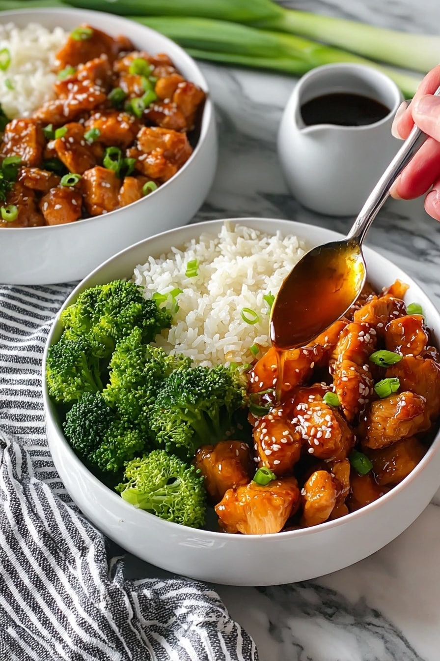 Easy Teriyaki Chicken Bowl Recipe 6 The image shows two white bowls filled with three main layers: at the bottom is a bed of fluffy white rice, topped on one side with bright green broccoli florets and on the other side with glossy, orange-brown glazed chicken chunks garnished with sesame seeds and small pieces of green onion. A woman's hand holds a spoon drizzling a shiny, amber sauce over the chicken in the front bowl. Next to the bowls is a small white cup filled with a dark dipping sauce, all placed on a white marbled surface with a striped cloth and some green onions in the background. Photo taken with an iphone --ar 2:3 --v 7 - Easy Teriyaki Chicken Bowl, easy chicken bowl, homemade teriyaki sauce, quick dinner recipe, healthy rice bowl
