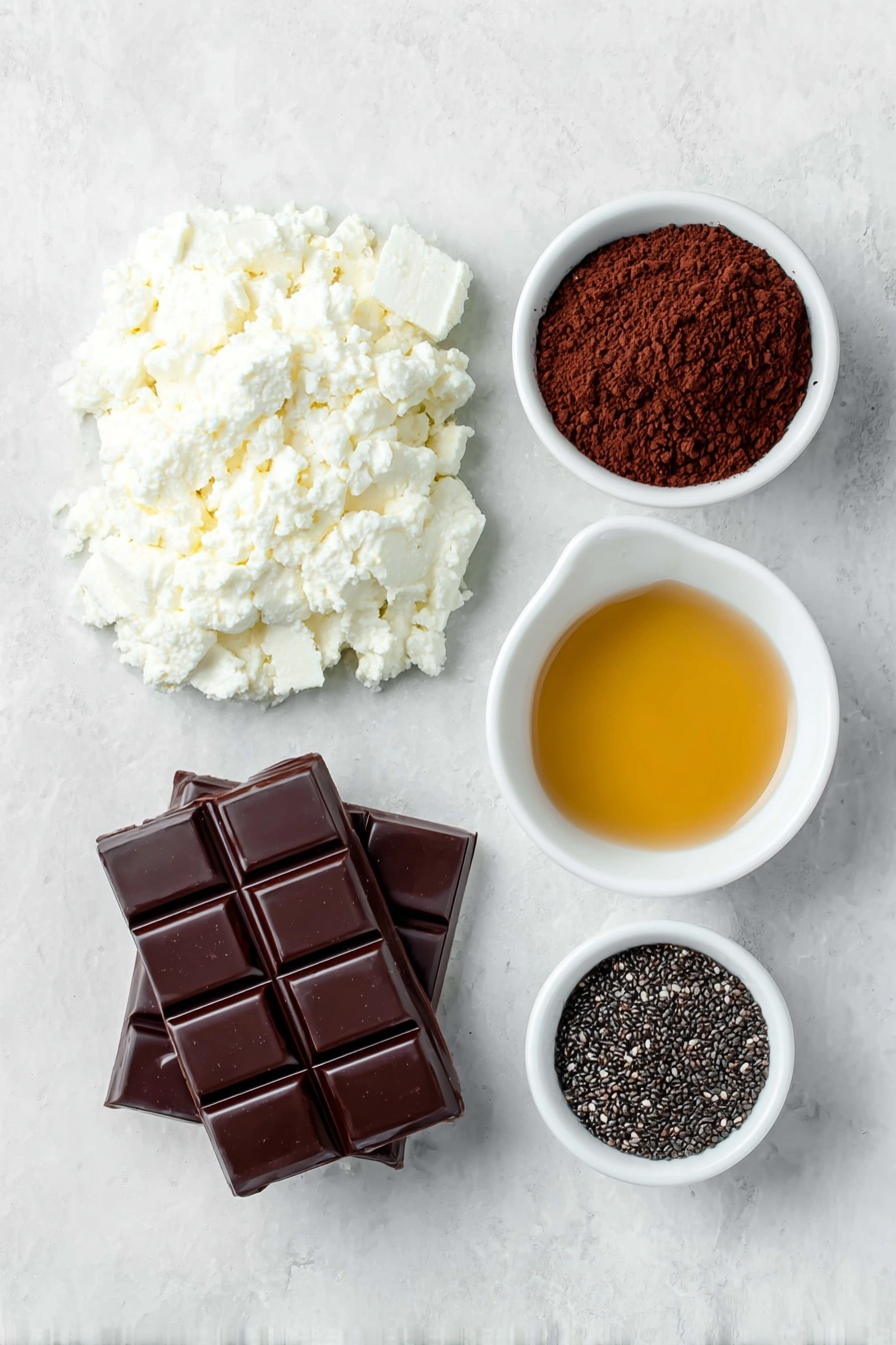 Cottage Cheese Chocolate Mousse Recipe 7 Flat lay of a small mound of fresh, white cottage cheese, a neat heap of rich dark brown cocoa powder, a small white ceramic bowl with smooth, glossy melted dark chocolate, a small white bowl filled with golden honey syrup, and a small white bowl holding shiny black chia seeds, all arranged symmetrically and balanced, placed on a clean white marble surface, soft natural light, photo taken with an iPhone, professional food photography style, fresh ingredients, white ceramic bowls, no bottles, no duplicates, no utensils, no packaging --ar 2:3 --v 7 --p m7354615311229779997 - Cottage Cheese Chocolate Mousse, healthy chocolate mousse, quick dessert recipes, protein-rich chocolate mousse, easy healthy desserts