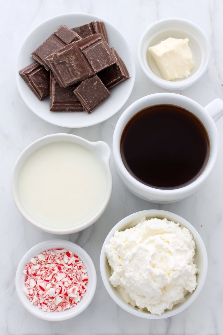 Peppermint Mocha Hot Chocolate Recipe 7 Flat lay of a small white ceramic bowl filled with fresh whole milk, a simple white ceramic cup of dark brewed coffee, a few chunks of chopped bittersweet chocolate neatly arranged on a white ceramic plate, a small white ceramic bowl containing clear peppermint extract, a dollop of freshly whipped cream on a small white ceramic dish, and a small pile of crushed red and white candy cane pieces on another white ceramic plate, all ingredients looking fresh and natural, perfectly balanced and symmetrical, placed on a clean white marble surface, soft natural light, photo taken with an iPhone, professional food photography style, fresh ingredients, white ceramic bowls, no bottles, no duplicates, no utensils, no packaging --ar 2:3 --v 7 --p m7354615311229779997 - Peppermint Mocha Hot Chocolate, festive hot chocolate, peppermint mocha drink, cozy winter beverages, easy holiday hot chocolate
