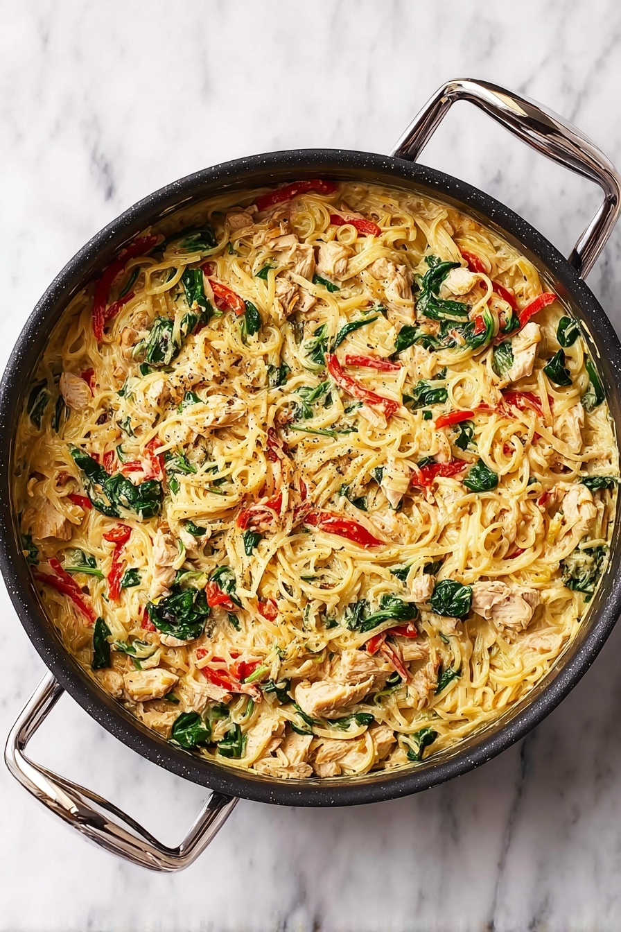 Tuscan Chicken with Spaghetti Squash Recipe 6 A large round black pan with two metal handles holds a creamy pasta dish. The pasta layer is tangled and light yellow, mixed with chunks of beige cooked chicken scattered evenly. Bright red strips of roasted peppers and fresh dark green spinach leaves are scattered throughout, adding color contrast. The creamy sauce that binds everything has a pale yellowish-white color, giving the dish a rich texture. The pan sits on a white marbled surface. Photo taken with an iphone --ar 2:3 --v 7 - Tuscan Chicken with Spaghetti Squash, healthy Tuscan chicken dinner, light Italian chicken recipes, quick weeknight chicken dishes, low-carb spaghetti squash recipes