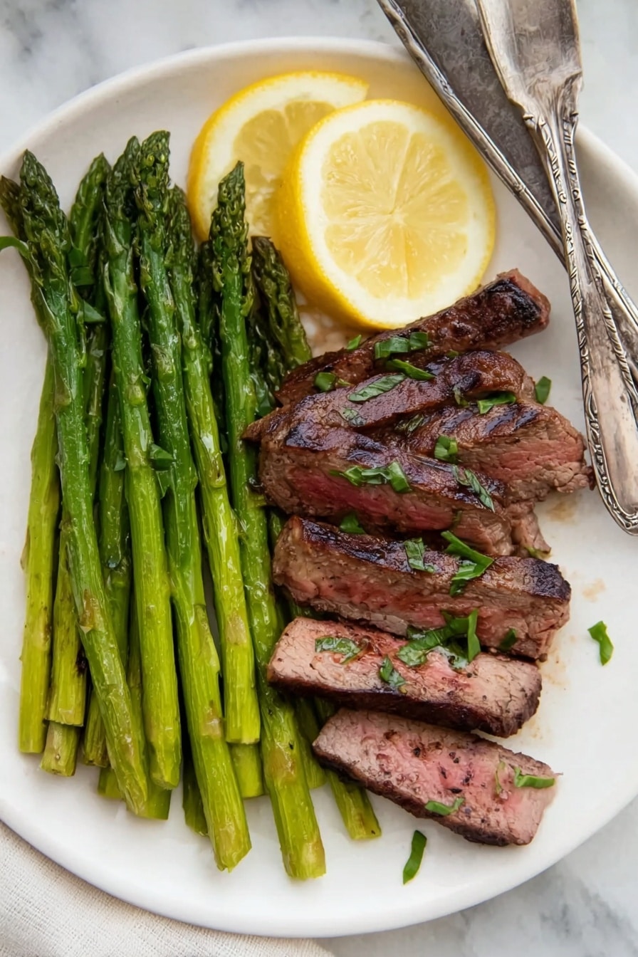 A white plate on a white marbled surface holds a food dish with two main layers. On the left side, there is a bunch of bright green grilled asparagus spears stacked neatly, topped with two thin slices of lemon placed on top of the asparagus near the top edge of the plate. On the right side, there are six pieces of grilled steak slices arranged in a slight fan shape, showing a brown outside with a slightly pink inside and small bits of green herbs sprinkled on top. At the top right edge of the plate, a vintage silver fork and knife rest side-by-side. Photo taken with an iphone --ar 2:3 --v 7 - Best Grilled Steak Marinade, grilled steak marinade, easy steak marinade recipe, flavorful steak marinade, succulent grilled steak
